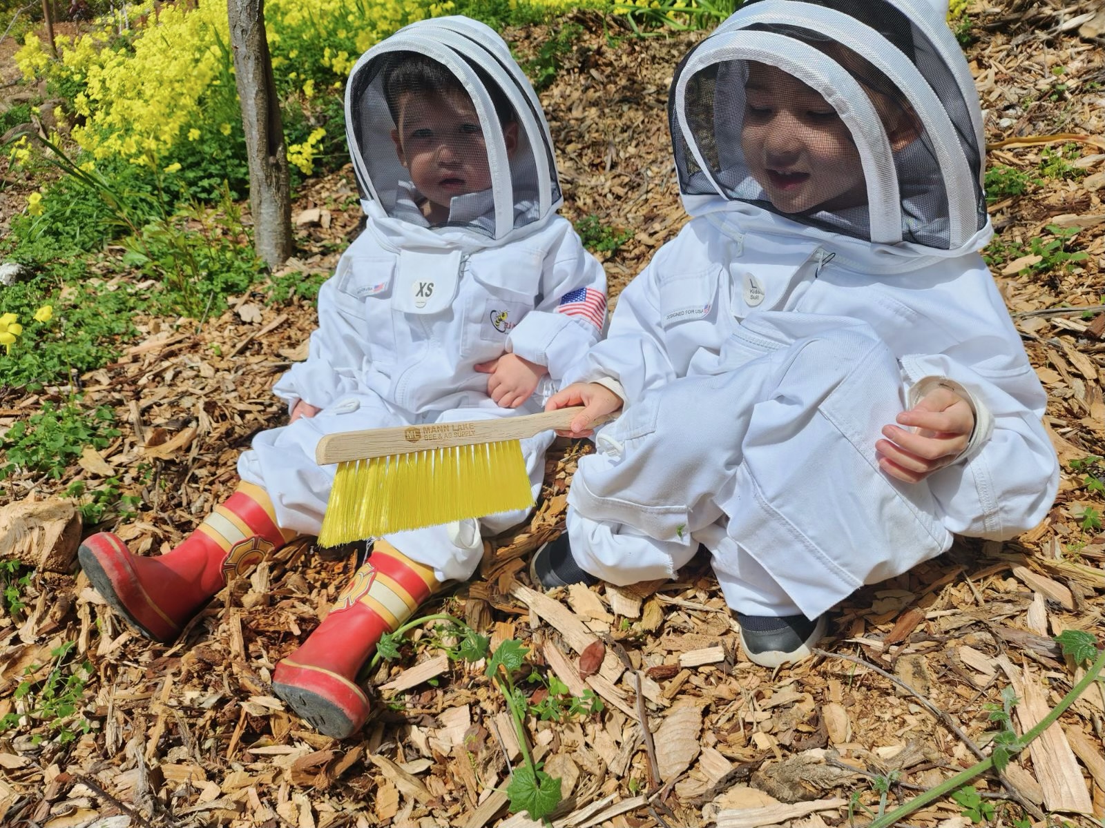 Children in bee suits learning about beekeeping at our Oakland farm